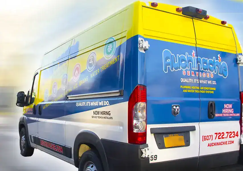 A commercial Auchinachie service van displays branding, contact info, and now hiring notices alongside plumbing, heating, and air conditioning services on the sides and rear.